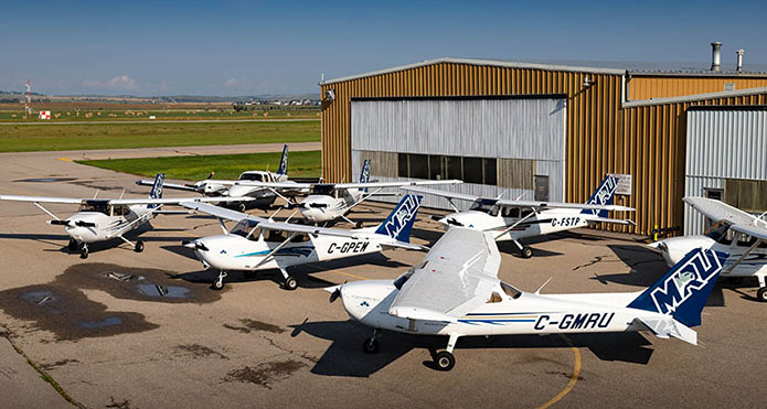 Seven MRU airplanes on the ground outside the Springbank hangar.