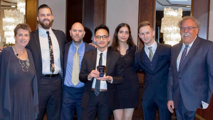 Accounting students Mia Baines and Jan Santiago and Social Innovation students Kolten Nelson and Xander Jensen and other event attendees posing with the third place Trophy for the Alberta Not-for-Profit Association (ANPA) case competition