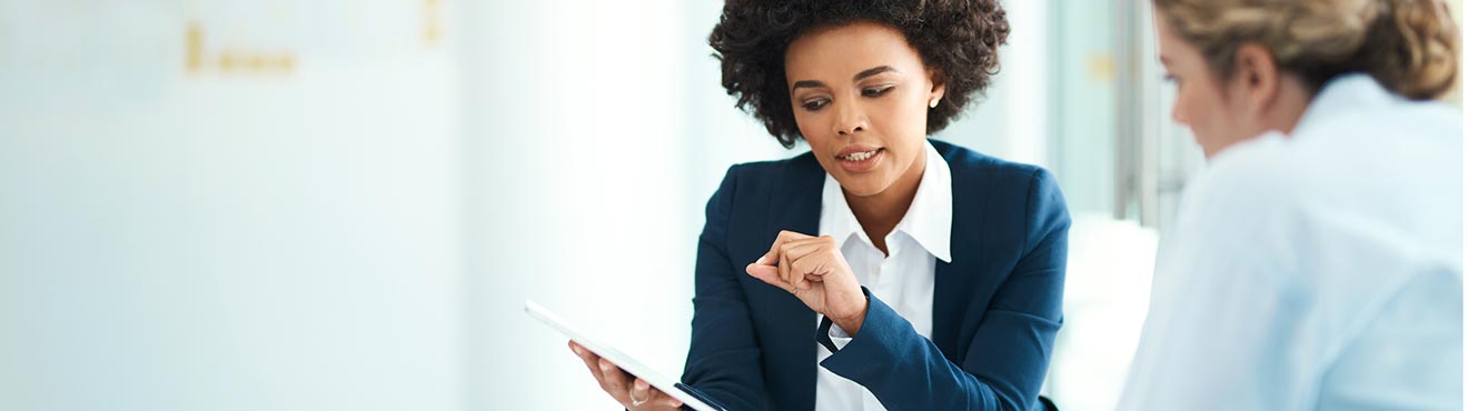 Financial professional shows something on a tablet to a client.