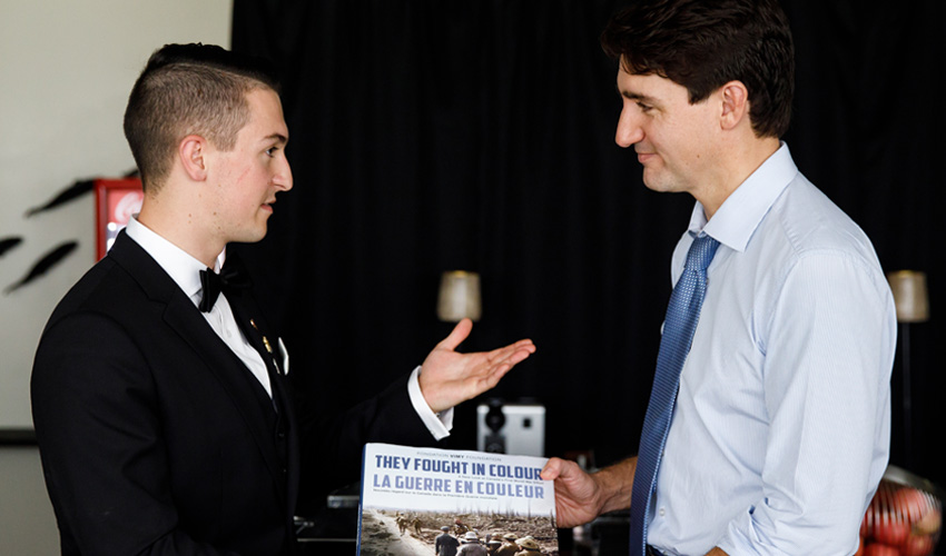 Michael Batas presenting Justin Trudeau with a book.