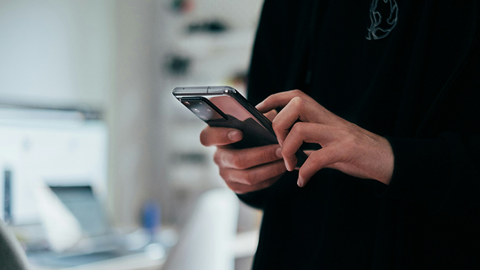 Person holds a mobile phone in their hands