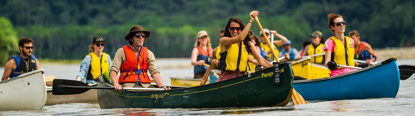 A group of students canoeing down a river.