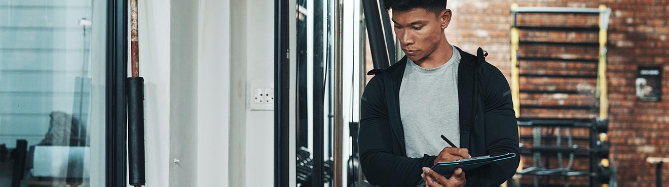 Fitness facility manager inspecing gym equipment.