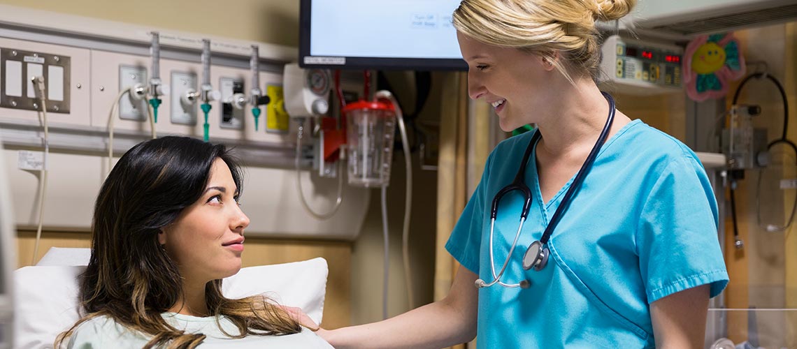 Two instructors overseeing students participating in a simulation in the Health Simulation Learning Centre.