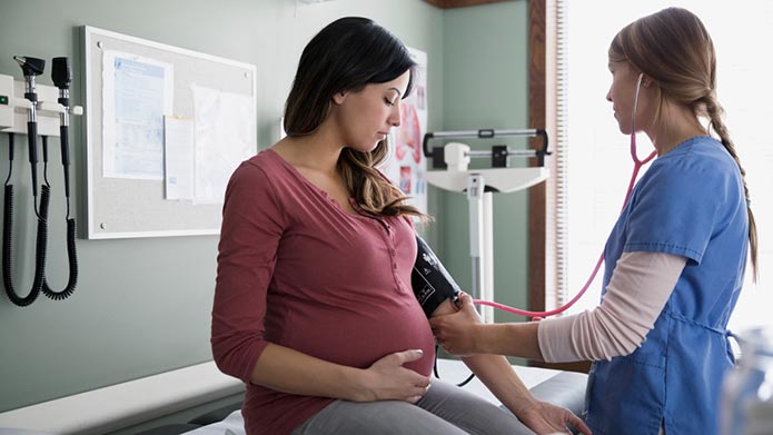 A Mount Royal midwifery student takes the blood pressure of a pregnant person.