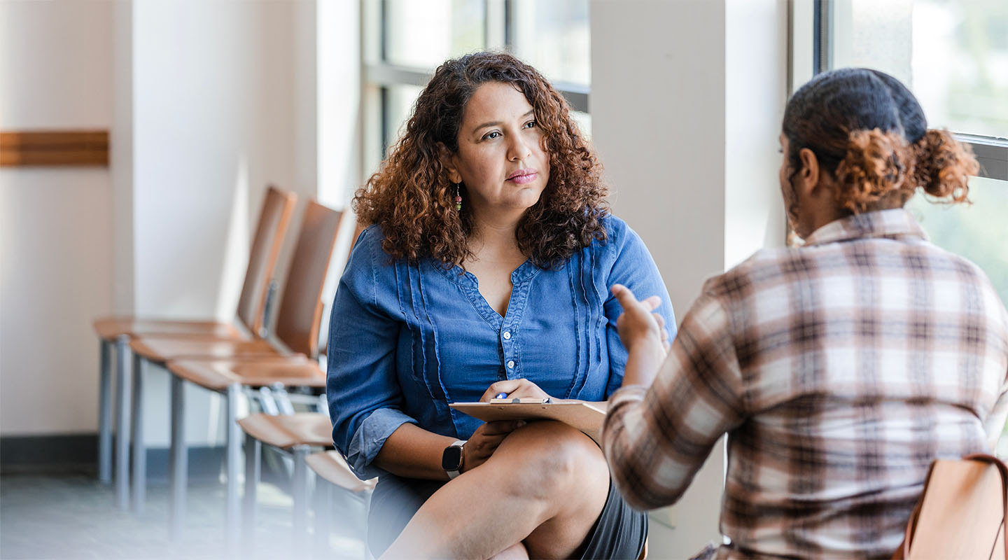 A social work professional sits listening to her client.