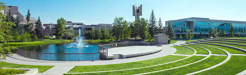 Image of the TransCanada Amphitheatre and Charlton Pond framed by the buildings of Mount Royal University.