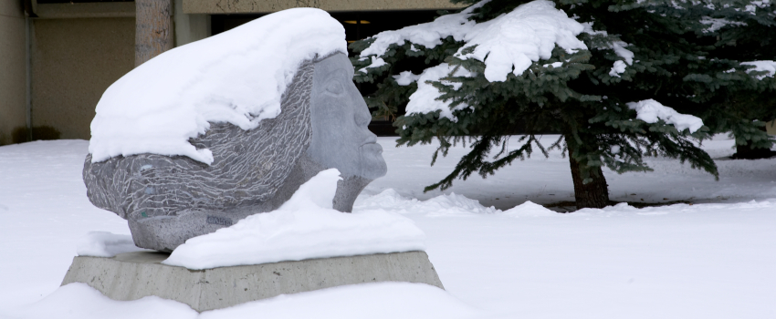 A stone head in the snow.