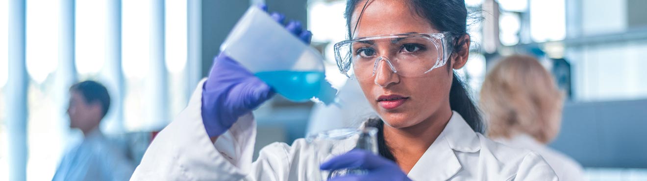 A student in a chemistry lab, measuring out a liquid.