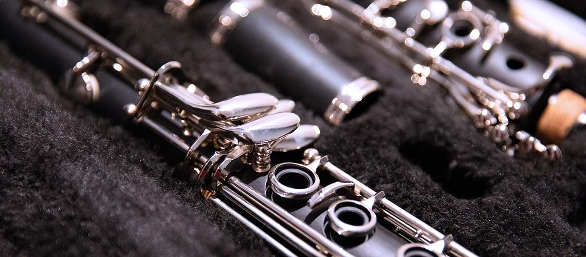 Close up photo of a disassembled clarinet in its case.