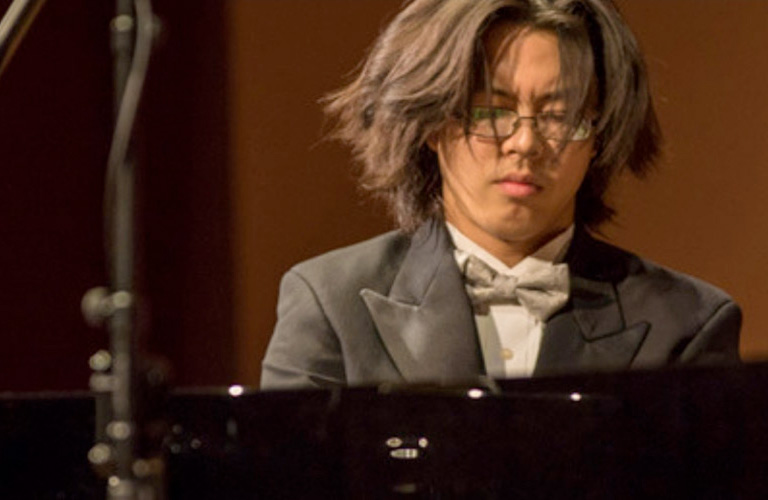 Student passionately performing the piano on stage