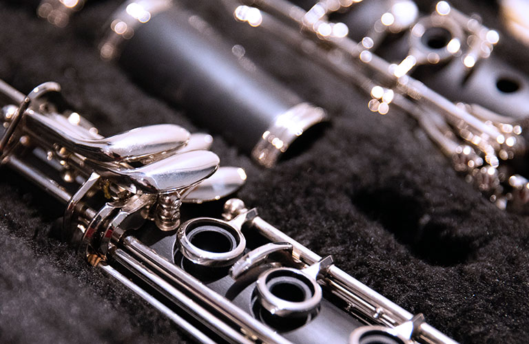 Close up photo of a disassembled clarinet in its case.