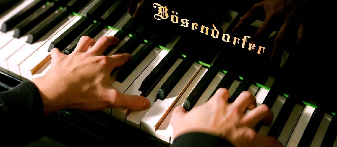 close up photo of a person's fingers on a piano.