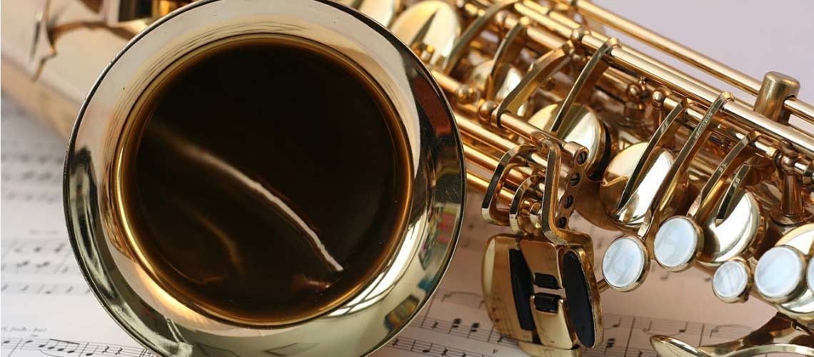 Close up photo of a saxahone on music sheets.