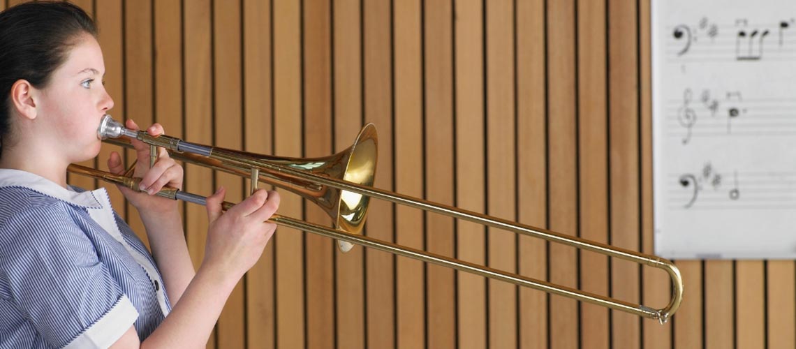 Photo of a person playing a trombone.
