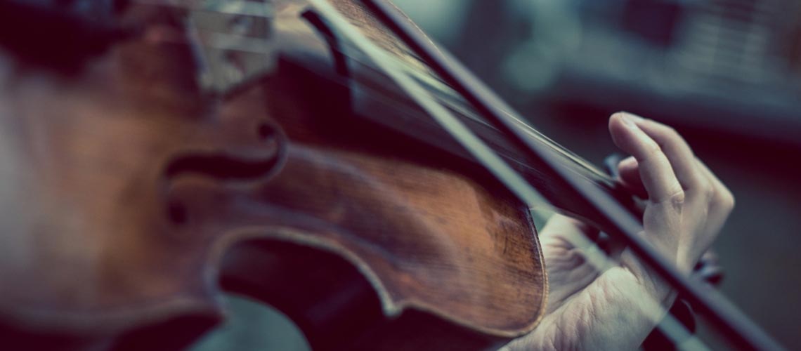 Close up image of a person playing a violin