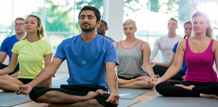 Adults sitting on the floor, legs crossed during a meditation