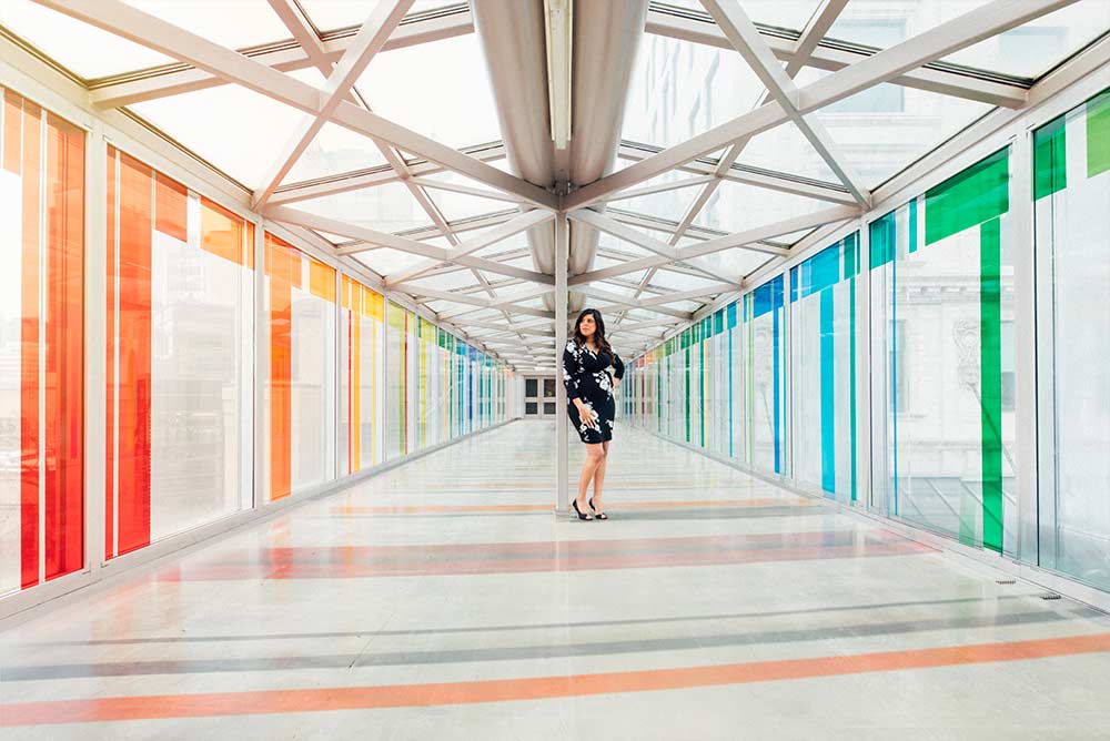 Famida Ahmad, Bachelor of Computer Information Systems alumna, centered in a colourful +15 in downtown Calgary