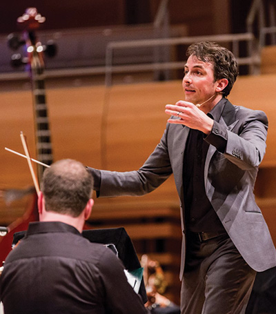 Adam Johnson conducting an orchestra