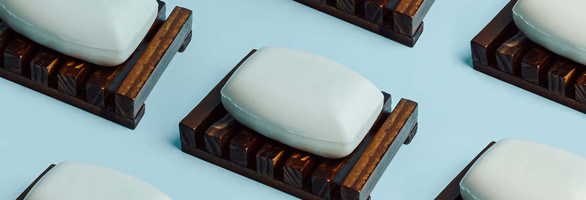 A repeating pattern of soap bars on wooden soap dishes.