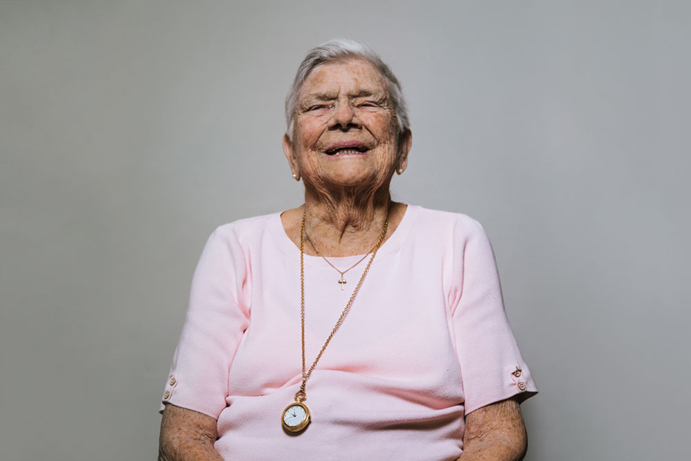 An older woman who has burst into laughter. Her emotion is almost radiant.