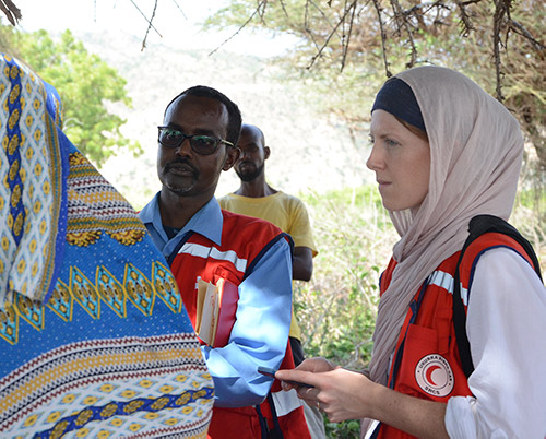 Corrie Butler and fellow Red Cross representative listen to a local.