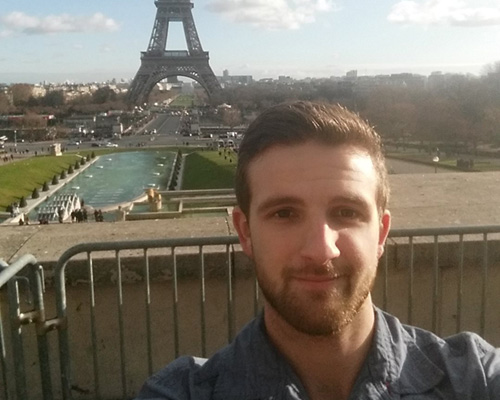 A selfie of Brandon Shokoples in front of the Eiffel Tower