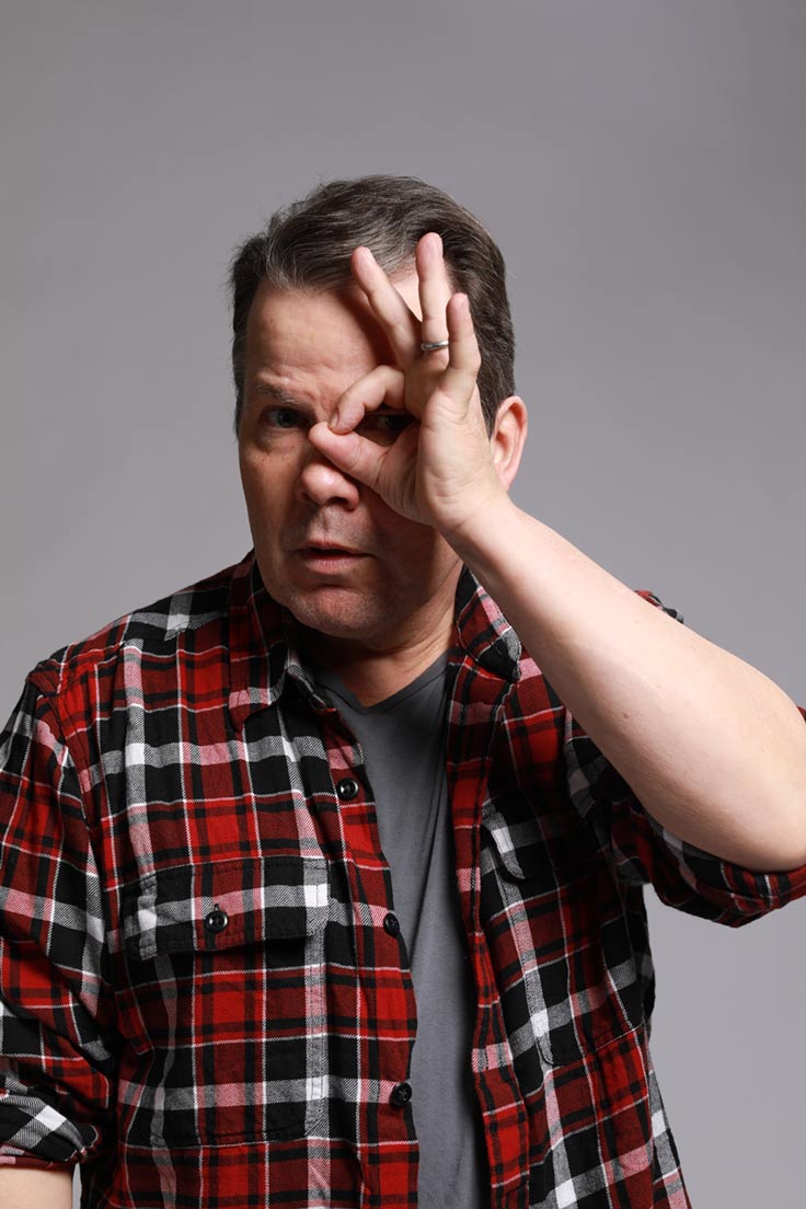 Photo of Bruce McCulloch holding his hand in the 'Okay' position over his left eye.