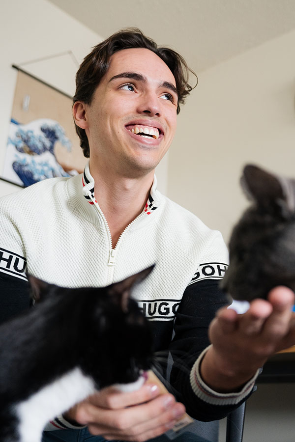 MRU Alum, Ben Rudolph, playing with his cats.