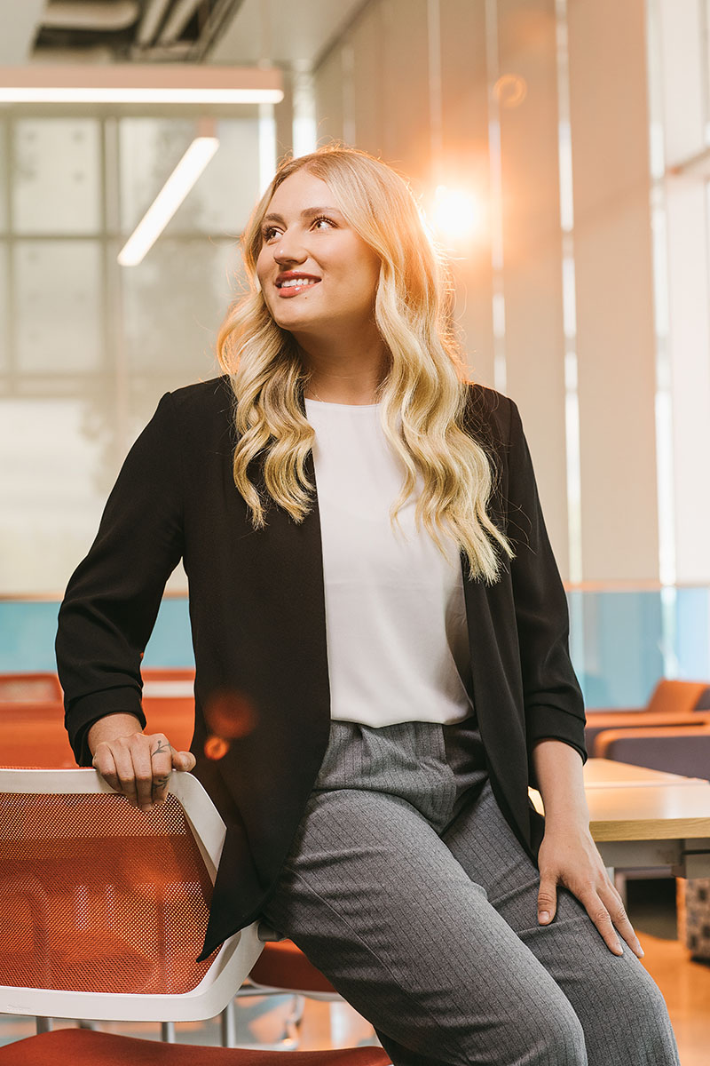 Tia McNeil in the Ideas Lounge, lit by the glow of a sunset.