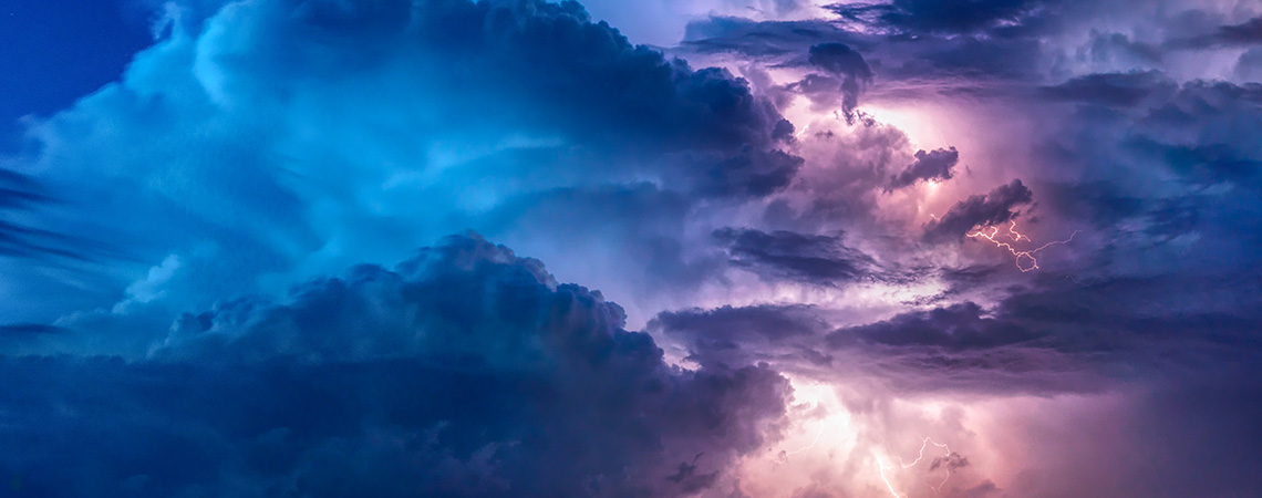 ramtically lit blue and pink clouds with lightning.