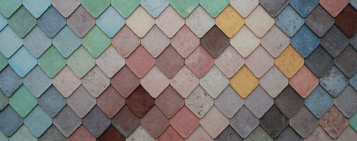 Many multicoloured, diamond-shaped shingles of a roof.