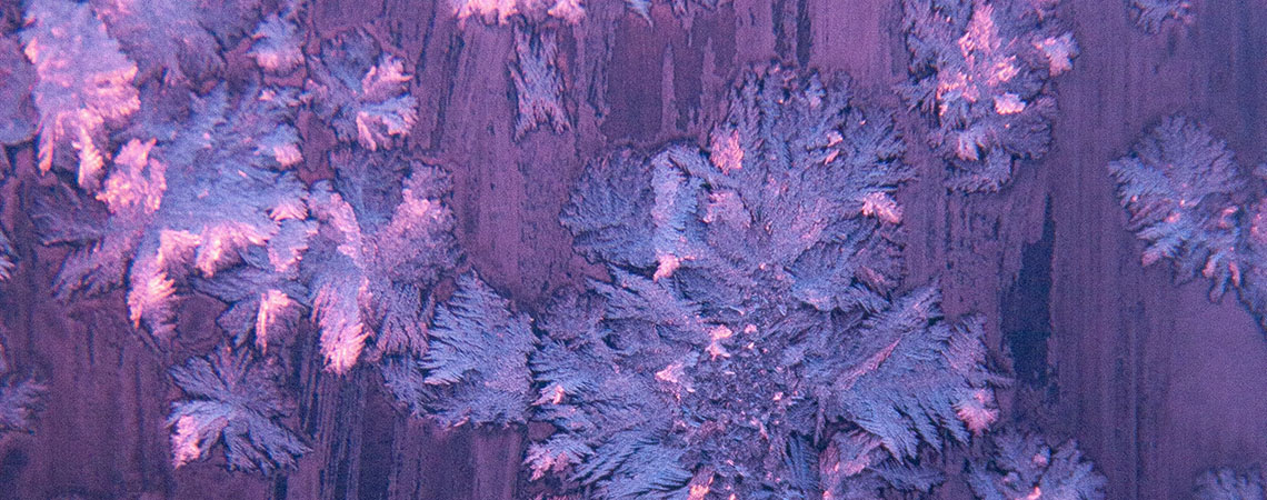 Photo of frost on a window but the glass appears pink.