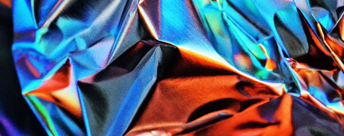 Abstract shapes and colours made from a crumpled sheet of aluminum foil.