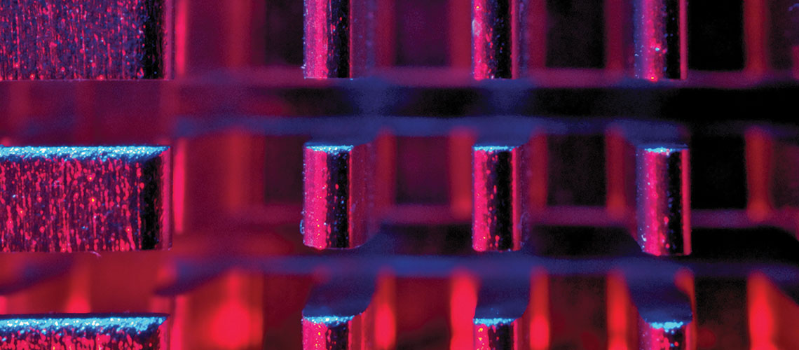 Close up photo of the pins on a heat sync lit dramatically by RGB lights.