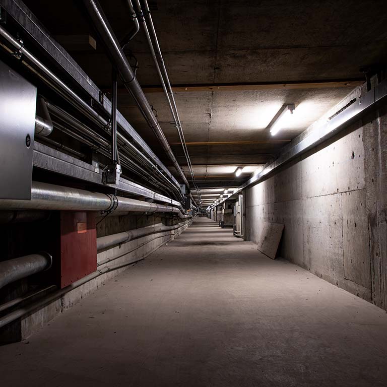 Photo of a unevenly lit, concrete tunnel.