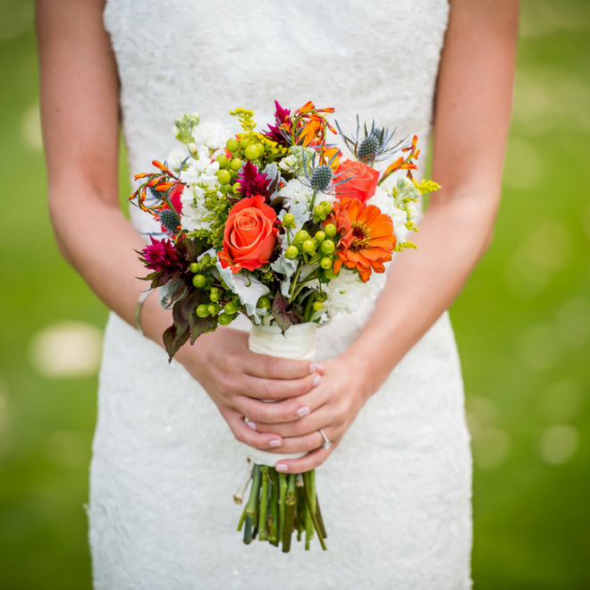 Person in a wedding dress holding a bouquet.