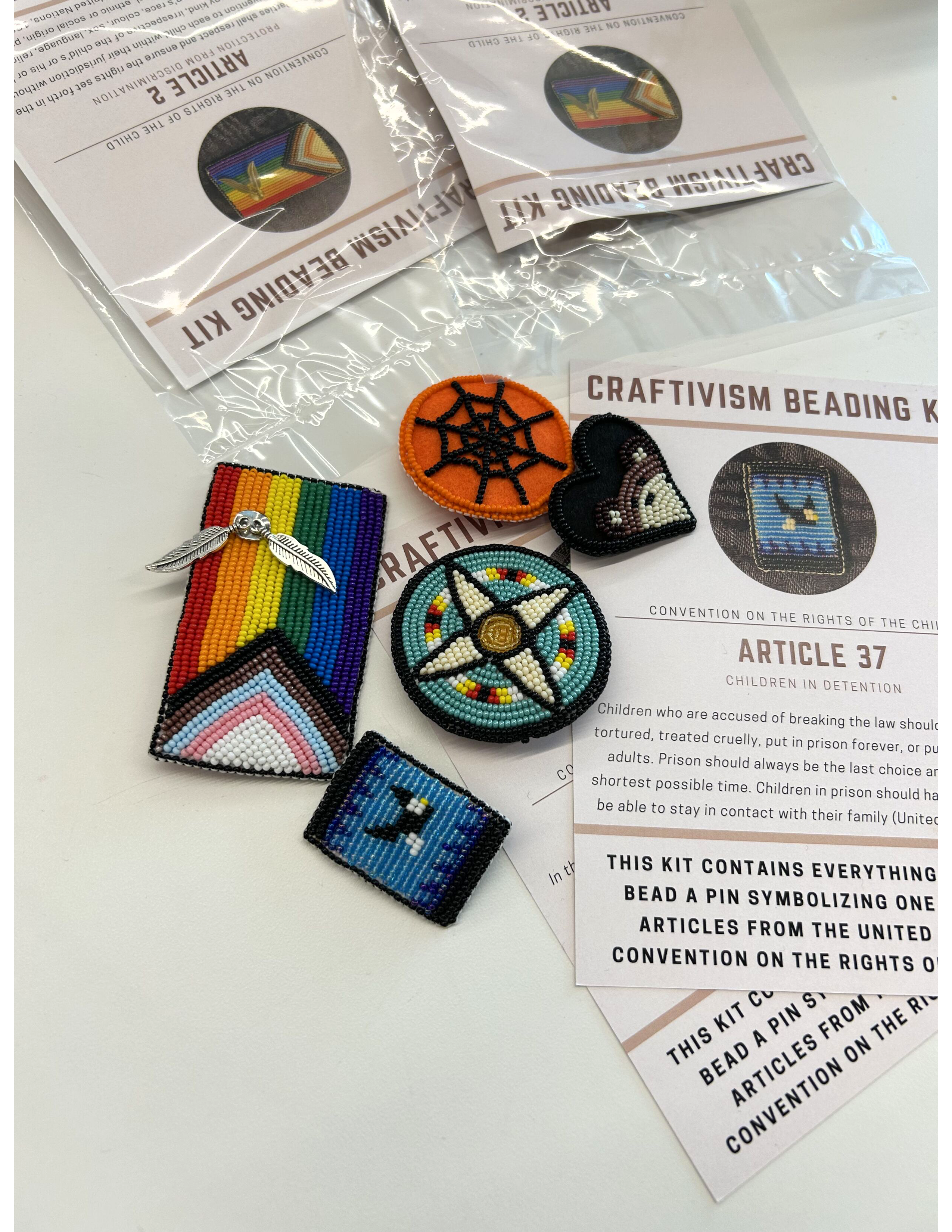 A table covered with colorful embroidered patches and enamel pins arranged in small groups.