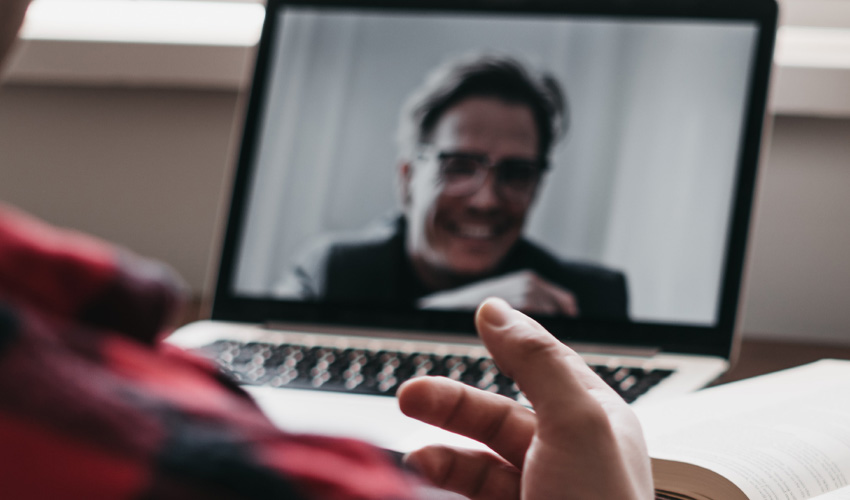 A psychologist conducting an online therapy session with his patient.